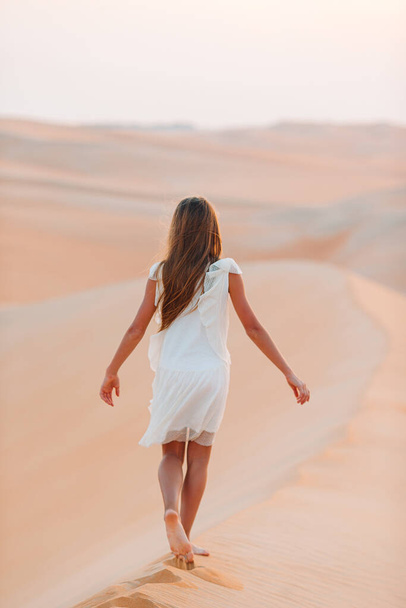 Girl among dunes in desert in United Arab Emirates - Фото, изображение