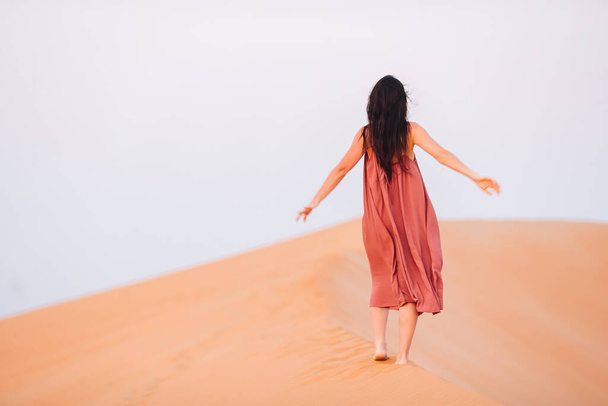 Girl among dunes in desert in United Arab Emirates - Photo, Image