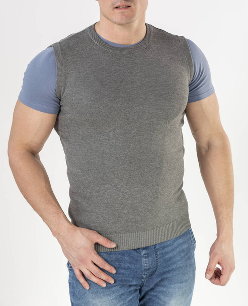 a man in a knitted vest and blue jeans on a white background - Foto, Imagen