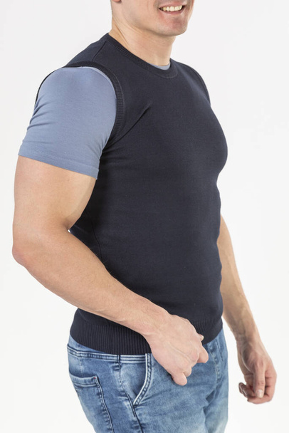 a man in a knitted vest and blue jeans on a white background - Foto, Bild