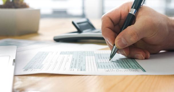 Person filling US tax form - Valokuva, kuva