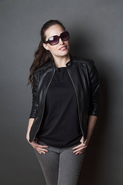 молода приваблива жінка в чорній футболці і чорній шкіряній куртці студійний знімок, сміється
 - Фото, зображення