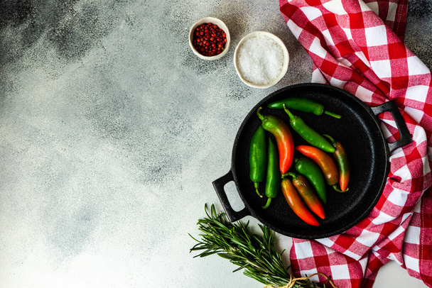 Cooking concept with pan, paprika peppers and spices on stone background with copy space - Photo, Image