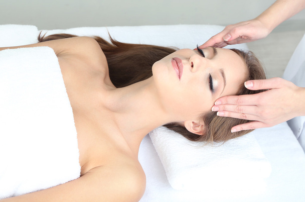 Beautiful young woman during facial massage in cosmetic salon close up - Foto, Imagem