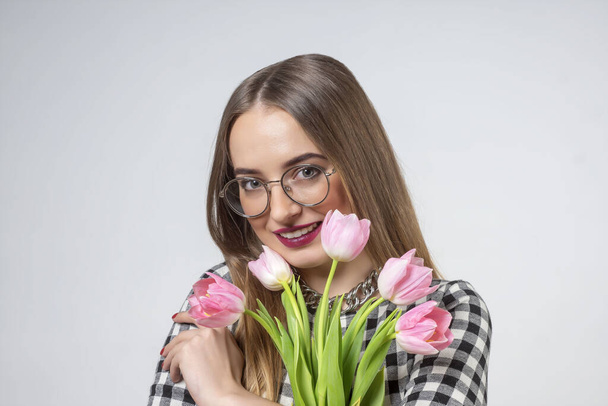 Young beautiful girl with pink tulips in her hands. - Foto, Imagem