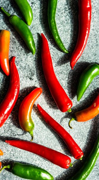 Trendy vegetable frame with ripe hot chilli peppers on stone background with deep shadows on stone background with copy space - Фото, изображение