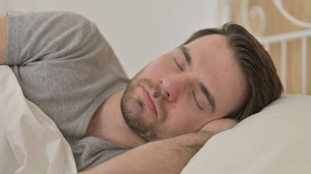 alszik az ágyban fiatalember portréja - Fotó, kép