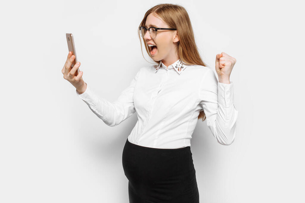 Image of a young pregnant business woman with glasses, angry and tired girl talking on the phone and shouting, isolated on a white background - Fotografie, Obrázek