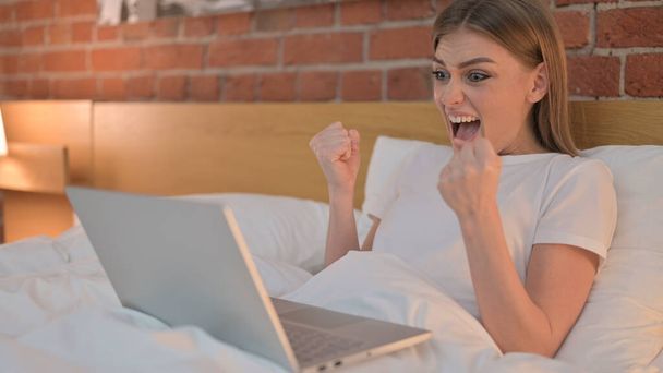 Ambiciózus fiatal nő ünnepli siker az ágyban - Fotó, kép