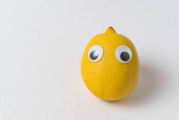 Fresh Lemon with eyes on white background. Food with Funny Face - Foto, Imagen