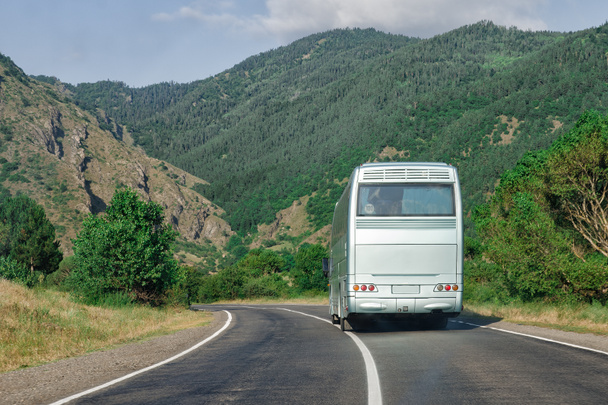 Bus blanc vierge sur l'autoroute de montagne. Vue arrière placer votre publicité
. - Photo, image