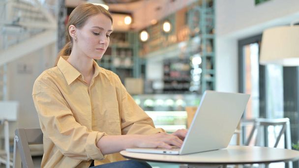 Mujer joven profesional usando el ordenador portátil en Café
 - Foto, imagen