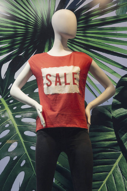 Окно дисплей с пятью манекенами носить футболки с текстом Продажа
 - Фото, изображение