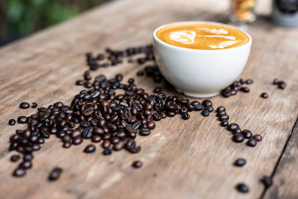 Kawa Latte art z fasolową fakturą na drewnianym stole, Gorący napój - Zdjęcie, obraz