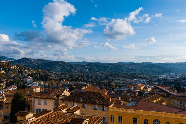 Panoramiczny widok na centrum miasta Cote d 'Azur i góry Alp nad Morzem Śródziemnym pod błękitnym nieco pochmurnym niebem (Grasse, Francja) - Zdjęcie, obraz