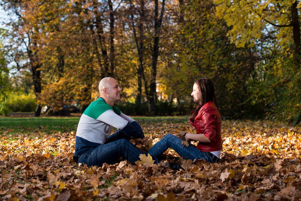 Beautiful Couple In The Heap Of Leaves - 写真・画像