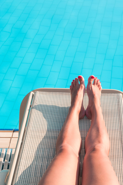 Female legs on sunbed at the pool - 写真・画像