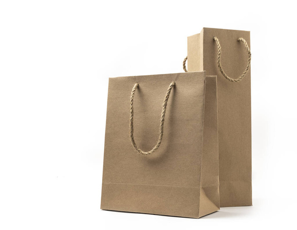 Dwie proporcje wielkości brązowej torby papierowej z naturalnym uchwytem liny, jedna jest krótka torba papierowa inne są wysokie, wąskie. Brązowe torby na białym tle. Pojęcie ekologii. - Zdjęcie, obraz