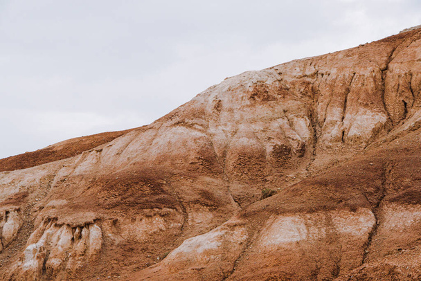 canyon met rode zandhellingen. Woestijnheuvels met bodemerosie, vorming van ravijnen als gevolg van droogte - Foto, afbeelding