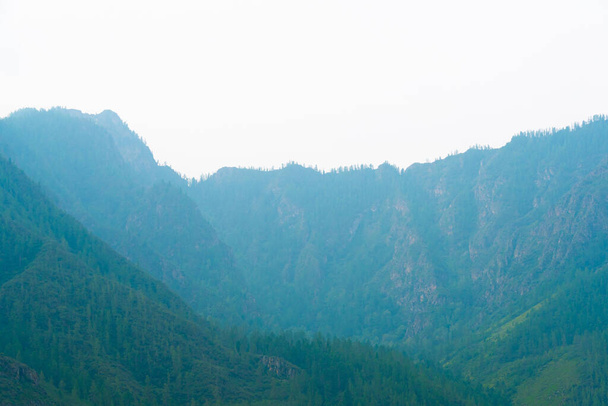 siluetas de montañas en neblina azul. Esquema de suaves colinas en el valle
 - Foto, Imagen