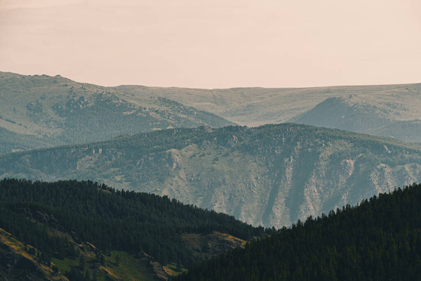 Colinas em névoa azul no horizonte. Silhuetas de montanhas no vale ao pôr do sol
 - Foto, Imagem