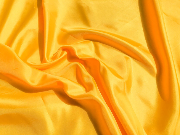 Gyönyörű sárga selyem vagy szatén textúra háttér másolási hely a design és a művészeti  - Fotó, kép