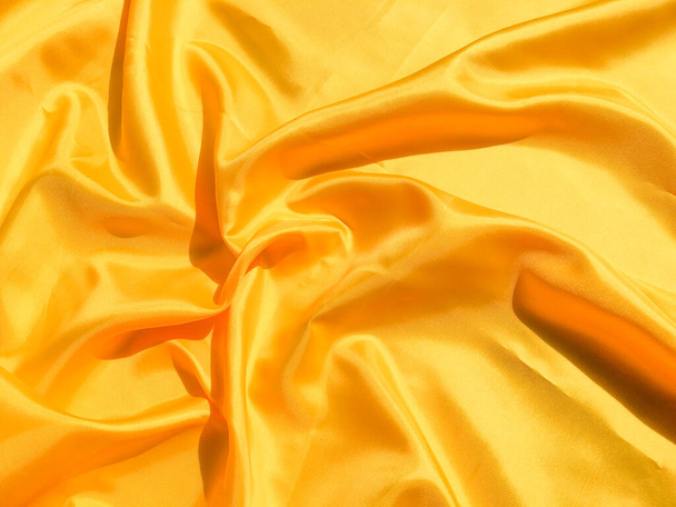 Beautiful yellow silk or satin texture background with copy space for design and artwork  - Фото, зображення