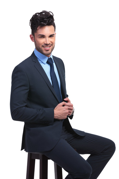smiling young business man sitting on a stool - Фото, зображення
