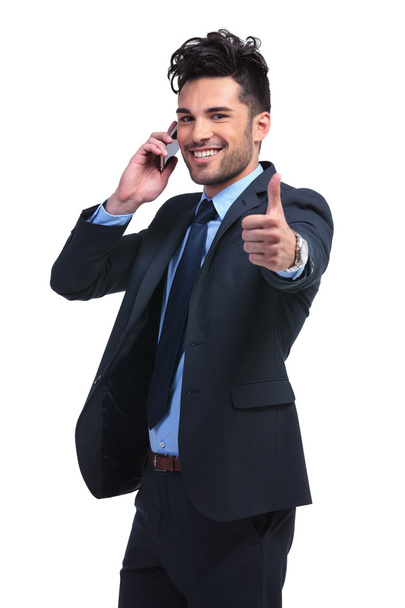 Молодой бизнесмен с очень хорошими новостями по телефону
 - Фото, изображение