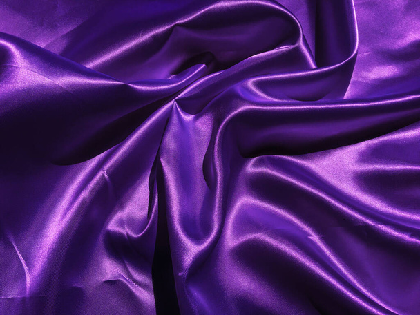 Gladde paarse stof of satijnen textuur achtergrond met kopieerruimte voor design - Foto, afbeelding