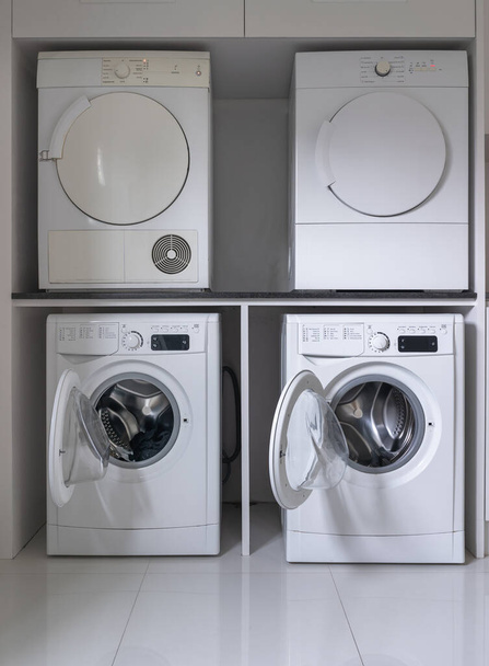 Laundry washing machine and dryer against modern appliance household in laundry room interior - Zdjęcie, obraz