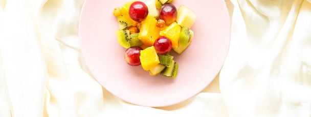 Свежий органический фруктовый салат на розовой тарелке, здоровое питание и детоксикация диеты план, плоский лежал
 - Фото, изображение