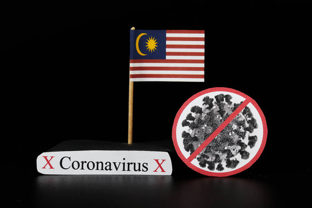 Національний прапор Малайзії з коміркою covid-19 і словом coronavirus. Хвороба швидко поширюється по цілому світі. Ковід-2019 - більш сильний грип, який вражає людей похилого віку. Небезпечні й агресивні. - Фото, зображення