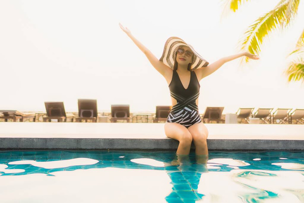 Портрет красива молода азіатка розслабляється навколо відкритого басейну в готельному курорті з пальмою на заході сонця або сходу сонця для відпочинку
 - Фото, зображення