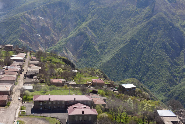 Blick von oben aus der Seilbahn auf Halidzor Dorf und Gebäude der Schule in den Bergen. Armenien, Region Syunik, Umgebung von Tatev - Foto, Bild