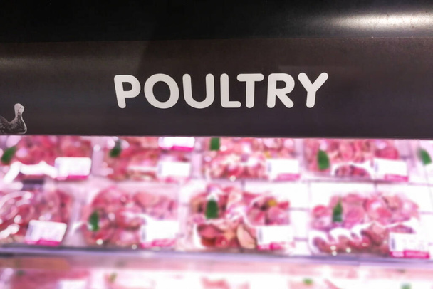 Süpermarketin bozulabilir ürün bölümündeki kümes hayvanları tabelaları çözünmüş arka plana sahip - Fotoğraf, Görsel