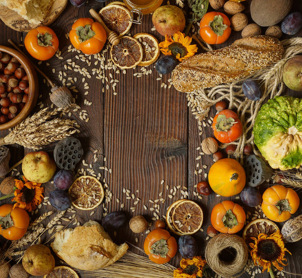 Kürbisse, Kaki, Getreide, Brot, Samen und Nüsse auf hölzernem Hintergrund, Ernte - Foto, Bild