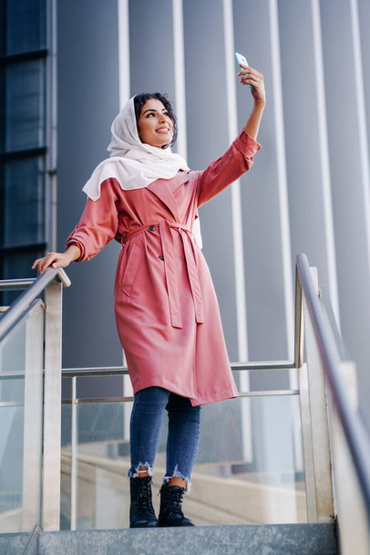 Donna musulmana con hijab scattare selfie con smartphone
 - Foto, immagini
