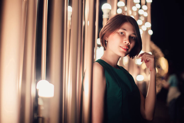 Asian young short hair beautiful woman posing on the decorated lights street at night, christmas, winter - 写真・画像