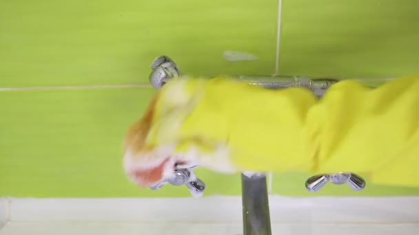 Una mano femenina en un guante de látex amarillo esponja una batidora de baño. Mucha espuma. El concepto de limpieza del baño, limpieza. Espacio de copia
. - Imágenes, Vídeo