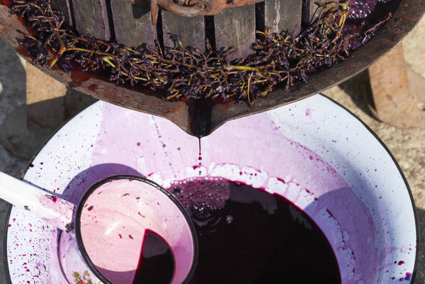 Elaboración. Tecnología de producción de vino en Moldavia. La antigua tradición popular del procesamiento de la uva. El exprimidor se utiliza para presionar el vino
.  - Foto, imagen
