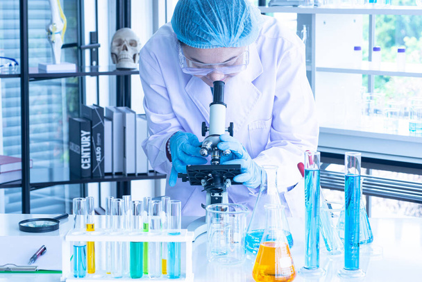 Asijská ženská vědkyně, výzkumnice, technika nebo student provedla výzkum nebo experiment pomocí mikroskopu, který je vědeckým vybavením v lékařské, chemické nebo biologické laboratoři - Fotografie, Obrázek