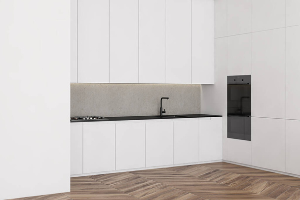 Corner of modern minimalistic kitchen with white and concrete walls, wooden floor, white countertops and cupboards with built in appliances. 3d rendering - Foto, immagini