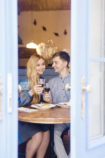 couple in blue clothes having dinner at a restaurant near the blue doors with a view of the city - Foto, Imagem