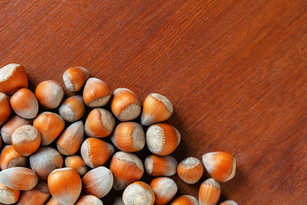 heap of hazelnuts on a wooden table, copy space, flat lay - Foto, immagini