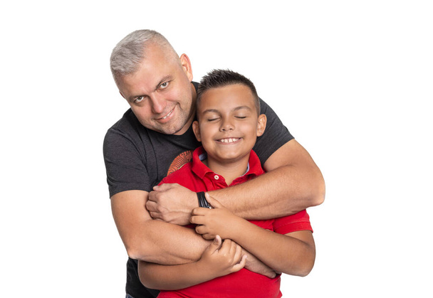 Vyötärö ylös muotokuva isä halaamalla poika valkoisella taustalla. Poika sulki silmänsä mielihyvin. Hyvien perhesuhteiden käsite
 - Valokuva, kuva