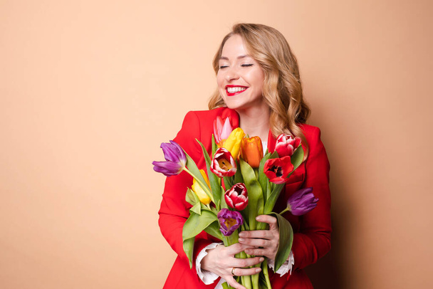 Happy beautiful woman posing with flowers and laughing - Fotó, kép