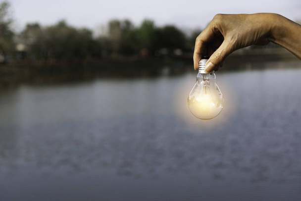 Innovációs és energetikai koncepció a kéz tart egy villanykörte és másol helyet beszúrni szöveg. - Fotó, kép