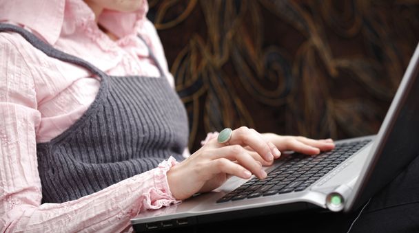 Dizüstü bilgisayarda çalışan genç bir kadın. - Fotoğraf, Görsel