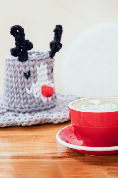Rode kop koffie cappuccino en leuke decoratieve gebreide mand - Foto, afbeelding